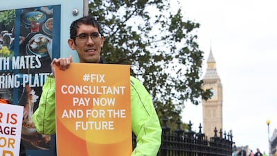 A health worker protests outside St Thomas’s Hospital, just south of the Thames in London. Reuters