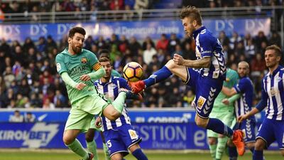 Barcelona’s Lionel Messi, left, duels for the ball with Alaves’s Aleksandar Katal. Alvaro Barrientos / AP Photo