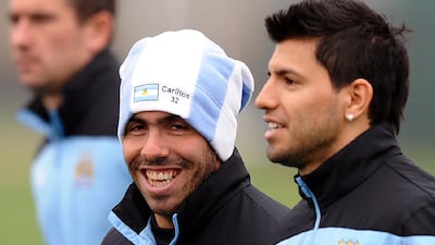 After serving suspension, Tevez started to train with the first team. Here he is seen having a laugh with Aguero, the man who had replaced him in the forward line. Paul Ellis / AFP