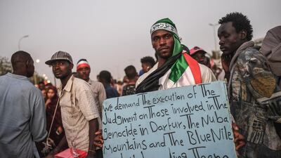 A Sudanese protester holds a placard during a protest outside the army complex in the capital Khartoum on April 20, 2019. AFP