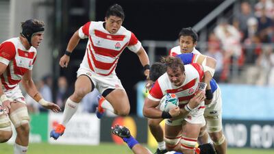 Japan's James Moore, right, is tackled at the City of Toyota Stadium. Associated Press