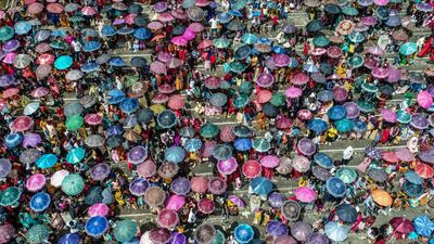 Spectators carry umbrellas during the annual Behdienkhlam festival in India. AFP