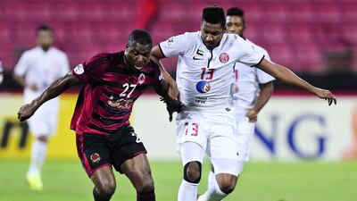 Al Rayyan's Yakubu Ayegbeni, left, tries to escape the attention of Jazira's Khamis Ismail. Karim Jaafar / AFP Photo