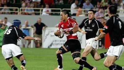 Japan's Takashi Kikutan is watched by the UAE's Tim Fletcher at The Sevens.