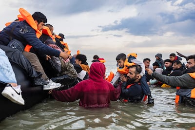 Migrants try to board a boat in northern France to cross the English Channel. AFP