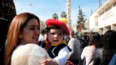 A woman carries a child in front of the Church of the Nativity in the biblical city of Bethlehem in the occupied West Bank. AFP