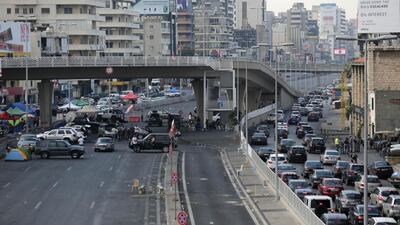 Cars, right, are stuck in a traffic jam as anti-government protesters, left, block a highway that links the capital Beirut to northern Lebanon by cars, tents, stones and bricks during a protest against the Lebanese government in the town of Jal El Dib north of Beirut, Lebanon. AP Photo