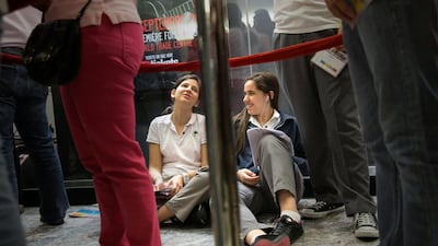 Farah Abed, 15, right, studies for their biology exam while queuing for One Direction tickets with her friend Leen Seifo, 15 at Abu Dhabi Mall. Silvia Razgova / The National