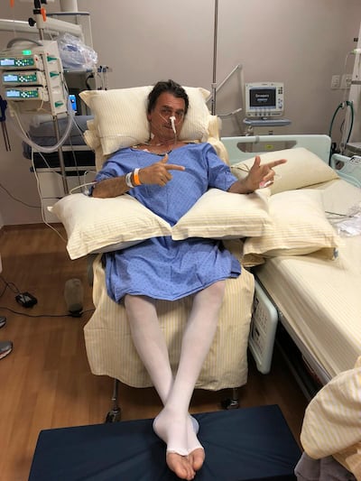 Presidential candidate Jair Bolsonaro poses for a photo while sitting in his hospital room at the Albert Einstein Hospital, in Sao Paulo, Brazil. National Social Liberal Party via AP