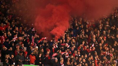 Supporters let off red smoke during the Europa League last 16 first leg match between Liverpool and Manchester United. Peter Powell / EPA