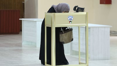 A Kuwaiti woman casts her vote during parliamentary elections in Kuwait City. Kuwait is holding its most inclusive elections in a decade, with some opposition groups ending a boycott after the country's royal rulers pledged not to interfere with Parliament. AFP