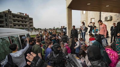 Children prepare to board a bus during the handover of orphans of suspected ISIS fighters to a Russian delegation by Syrian Kurdish officials in Qamishli, north-east Syria. Thirty-four children were to be repatriated. AFP