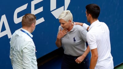 Novak Djokovic tries to help the line judge. EPA