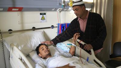Mohammad Solaiman tends to his injured nephew, Didar Alam, at Al Mafraq Hospital. Mr Alam broke his back escaping the Mussaffah fire last Friday. Families of victims are mourning their losses, while survivors’ relatives have rallied to offer help. Ravindranath K / The National