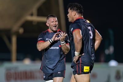 David Gairn of Dubai Exiles congratulates Duane Aholelei on his try against Dubai Hurricanes. Christopher Pike for The National