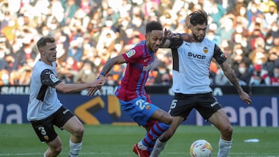 Barcelona's Pierre-Emerick Aubameyang vies with Valencia defenders Toni Lato and Omar Alderete at the Mestalla stadium in Valencia. AFP.