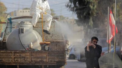 A municipal worker sprays disinfectant in the suburb of Beir Hassan, Beirut. AP Photo