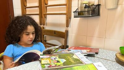 Nora Younis's daughter, who will move to grade four next year, taking a look at books shared by another parent. Photo: Nora Younis
