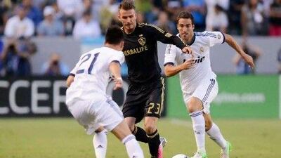 CARSON, CA - AUGUST 02: David Beckham #23 of Los Angeles Galaxy maneuvers the ball in between Gonzalo Higua‡n #20 and Jos‡© Maria Callej‡³n #21 of Real Madrid during the World Football Challenge at The Home Depot Center on August 2, 2012 in Carson, California. Kevork Djansezian/Getty Images/AFP