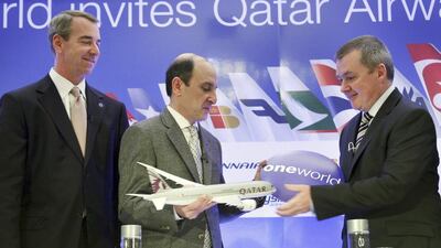 The chief executive of Qatar Airways, Akbar Al Baker, centre, exchanges a gift with IAG chief, Willie Walsh, as American Airlines chief executive, Tom Horton, looks on in New York. AP Photo