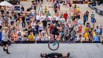 A crowd watches a biker showing his skills.
