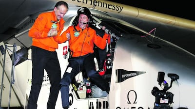 Solar Impulse 2 pilots Bertrand Piccard, right, and Andre Borschberg celebrate the world's first round-the-world flight to be powered solely by the sun's energy. Peter Klaunzer / Keystone via AP
