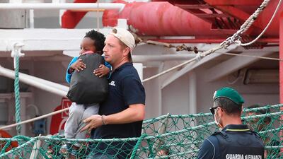 A child is carried as he disembarks the Ocean Viking, the second rescue boat to be allowed to dock in Italy since the formation of a new coalition government. AP