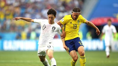 Lee Jae-Sung of South Korea challenges for the ball with Gustav Svensson of Sweden. Clive Mason / Getty Images