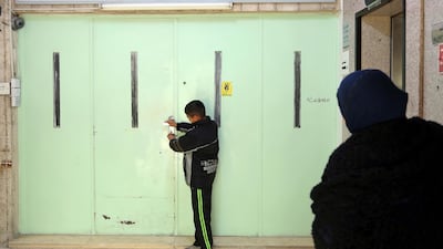 In this April 13, 2016 photo, a boy stands at the main entrance of the original Muslim Brotherhood office, that is sealed with wax after it was raided and shut down by police in Amman, Jordan. Raad Adayleh / AP