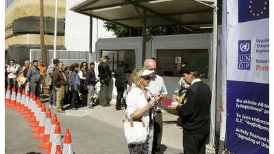 A Turkish officer checks passports next to the UN buffer zone in divided Nicosia, Cyprus.
