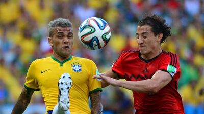 Brazil defender Dani Alves vies with Mexico defender Andres Guardado during their Group A match on Tuesday at the 2014 World Cup in Fortaleza, Brazil. Yuri Cortez / AFP