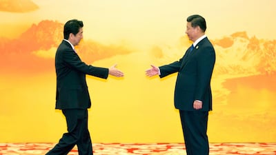 Japan's Prime Minister Shinzo Abe reaches out to shake hands with Chinese President Xi Jinping during a welcome ceremony for the Asia-Pacific Economic Cooperation (APEC) Economic Leaders Meeting in Beijing in 2014. AP Photo