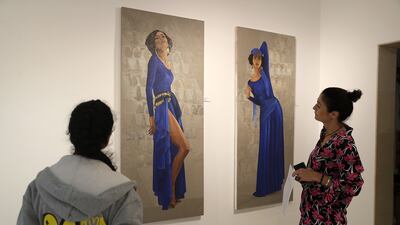 Another two stretched canvases depict dancers draped in a royal blue full-length dress