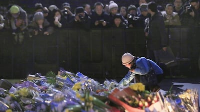 A woman lights a candle during a memorial ceremony on January 2, 2015, for people killed in a stampede on New Year’s Eve in Shanghai. Aly Song / Reuters