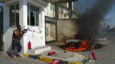 A Libyan rebel fighter takes up fighting position during an attack by pro-Gaddafi forces after rebels seized a Gaddafi army women's officer training center in Tripoli August 22, 2011. Ongoing fighting with snipers and other pro-Gaddafi forces has prevente???