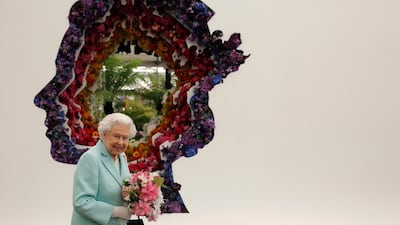 LONDON, ENGLAND - MAY 23: Queen Elizabeth II is pictured next to a floral exhibit by the New Covent Garden Flower Market, which features an image of the Queen, at Chelsea Flower Show press day at Royal Hospital Chelsea on May 23, 2016 in London, England. The show, which has run annually since 1913 in the grounds of the Royal Hospital Chelsea, is open to the public from 24-28 May. (Photo by Adrian Dennis - WP Pool/Getty Images)