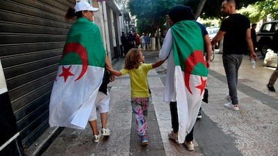 Algerians draped in national flags take part in a demonstration against the ruling class in the capital Algiers. AFP