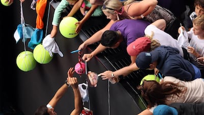 Serbia's Novak Djokovic gives autographs after victory against Japan's Yoshihito Nishioka in Melbourne, Australia. AFP