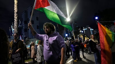 A protester waves a Palestinian flag in Tel Aviv at a demonstration against Prime Minister Benjamin Netanyahu's far-right government. AP