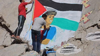 Palestinian artists paint a mural of Spanish footballer Lamine Yamal on the rubble of buildings destroyed in the war, at Shati refugee camp in Gaza city. AFP