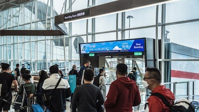 Travellers line up to board a Cathay Pacific flight at Hong Kong International Airport. Bloomberg
