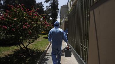 Medical personnel walk in the street during the vaccination campaign for older adults against Covid-19, in Lima, Peru. EPA
