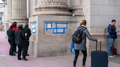 Blue tape and plastic cover swastikas drawn by vandals on the front of Union Station. AP