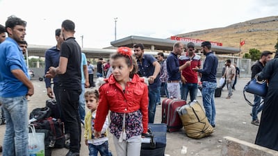 Syrian people carry their belongings as they cross the Cilvegozu border gate to the Turkish side on October 9, 2017 at Reyhanli district in Hatay. Ilyas Akengin / AFP