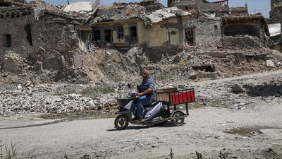 A man rides a scooter cart along a damaged street in the western part of Iraq's northern city of Mosul on August 10, 2019. AFP