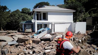 A general view of destroyed structures as a member of the South African Police Service (SAPS) K9 search-and-rescue unit searches for a missing 21-year-old man in KwaNdengezi, west of Durban. AFP