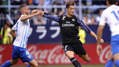 Real Madrid’s Cristiano Ronaldo fights for the ball against Malaga’s Mikel Villanueva. Daniel Tejedor / AP Photo