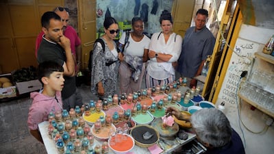 Tourists and locals look on as the craftsman creates his pieces. Reuters