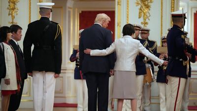 Ms Takaichi ushers Mr Trump as they review a guard of honour at Akasaka Palace in Tokyo. AP