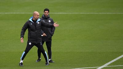 Pep Guardiola, left, talks to Mikel Arteta. PA